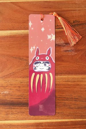marque-page illustré représentant un totoro deguisé en daruma, avec un pompon orange